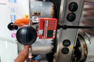 Medidor de estresse térmico com termômetro de globo instalado junto a um equipamento industrial.